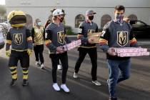 Golden Knights players Max Pacioretty, from right, Nick Holden and Zach Whitecloud load pizzas ...