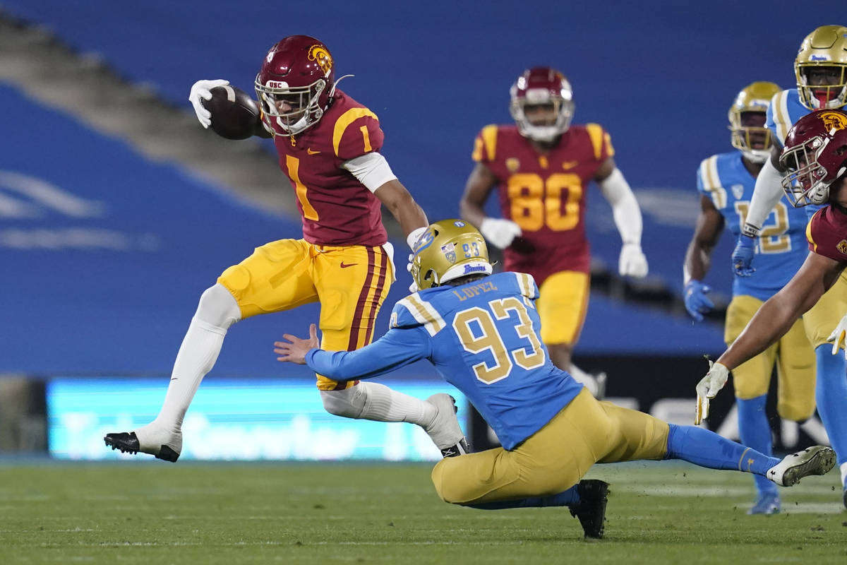 Southern California wide receiver Gary Bryant Jr. (1) avoids a tackle by UCLA place kicker RJ L ...