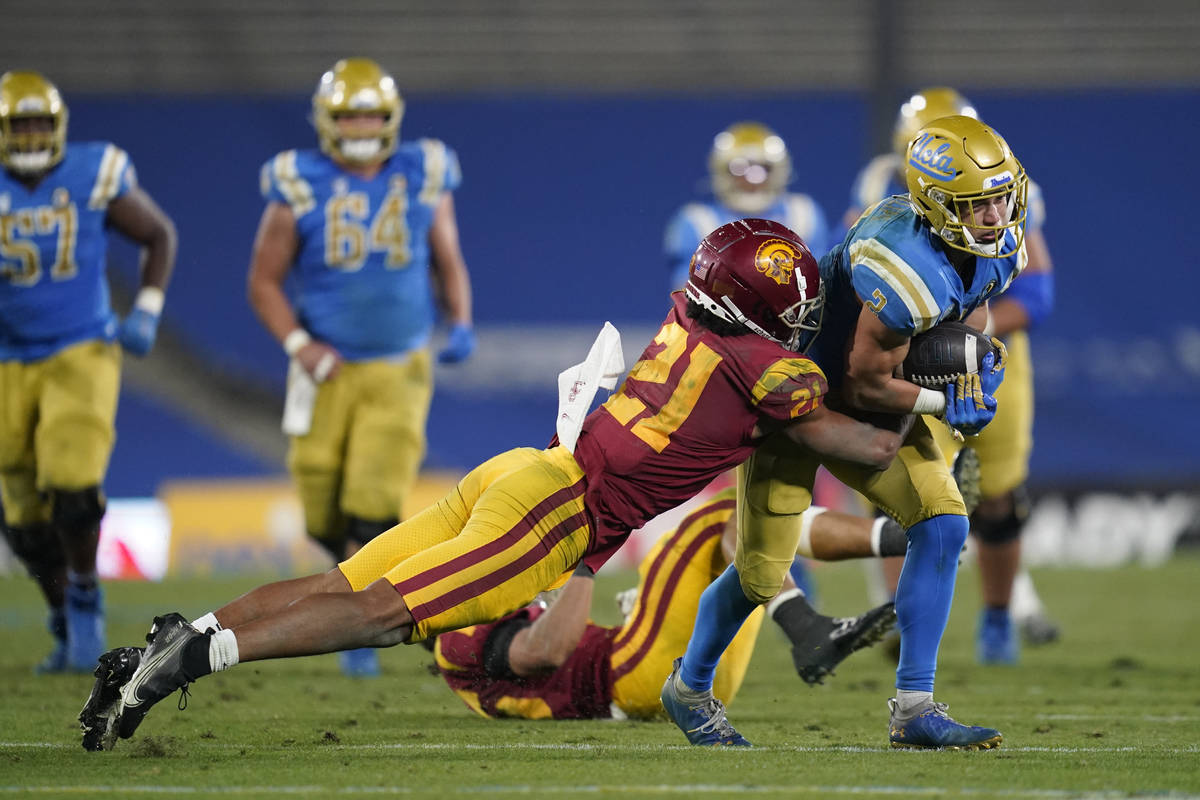 Southern California safety Isaiah Pola-Mao (21) tackles UCLA wide receiver Kyle Philips (2) dur ...
