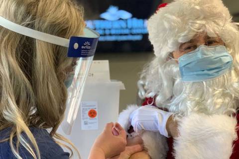 Santa sits for his COVID-19 Pfizer vaccination from nurse Karla Bee at Southern Hills Hospital ...