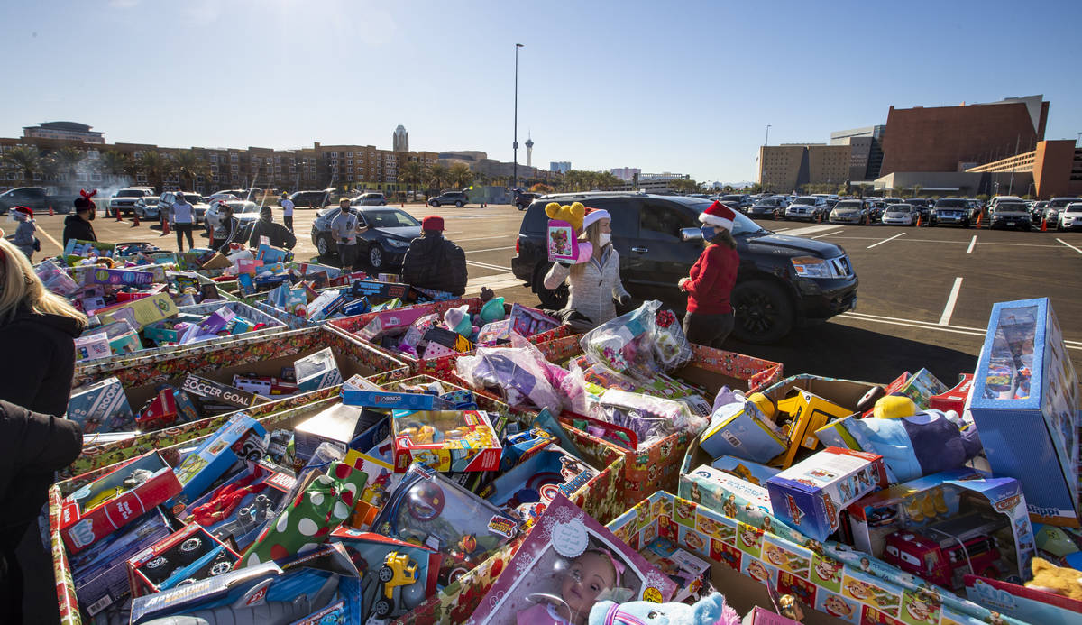 Volunteers greet drivers with toys as the Las Vegas Rescue Mission holds its toy drive on a fir ...