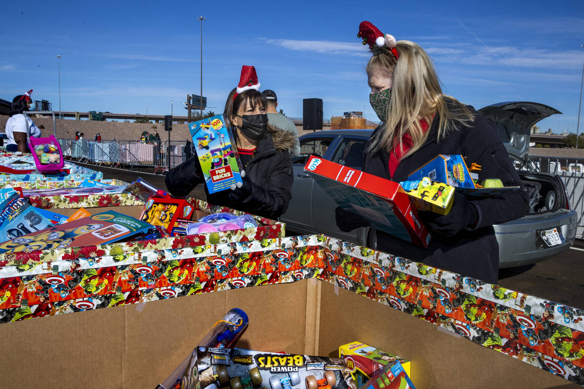 Gina Jones, left, and Patti Dillon grab more gifts to be distributed as the Las Vegas Rescue Mi ...