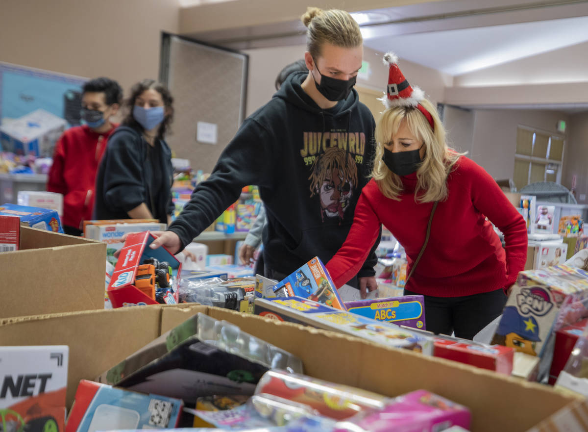 Volunteers Tanner Phillips, 17, left, and Jayme Phillips, 50, of Henderson pack Christmas donat ...