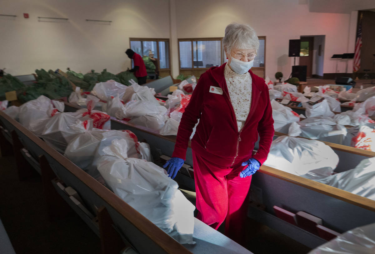 Volunteer Aldona Leskys, 76, of Henderson, organizes individual family Christmas presents, at t ...