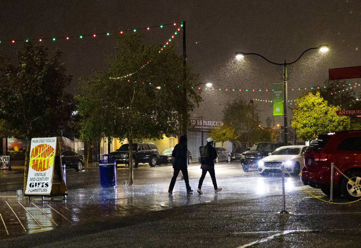 Pedestrians walk through the rain in the Arts District in Las Vegas, Thursday, Dec. 17, 2020. T ...