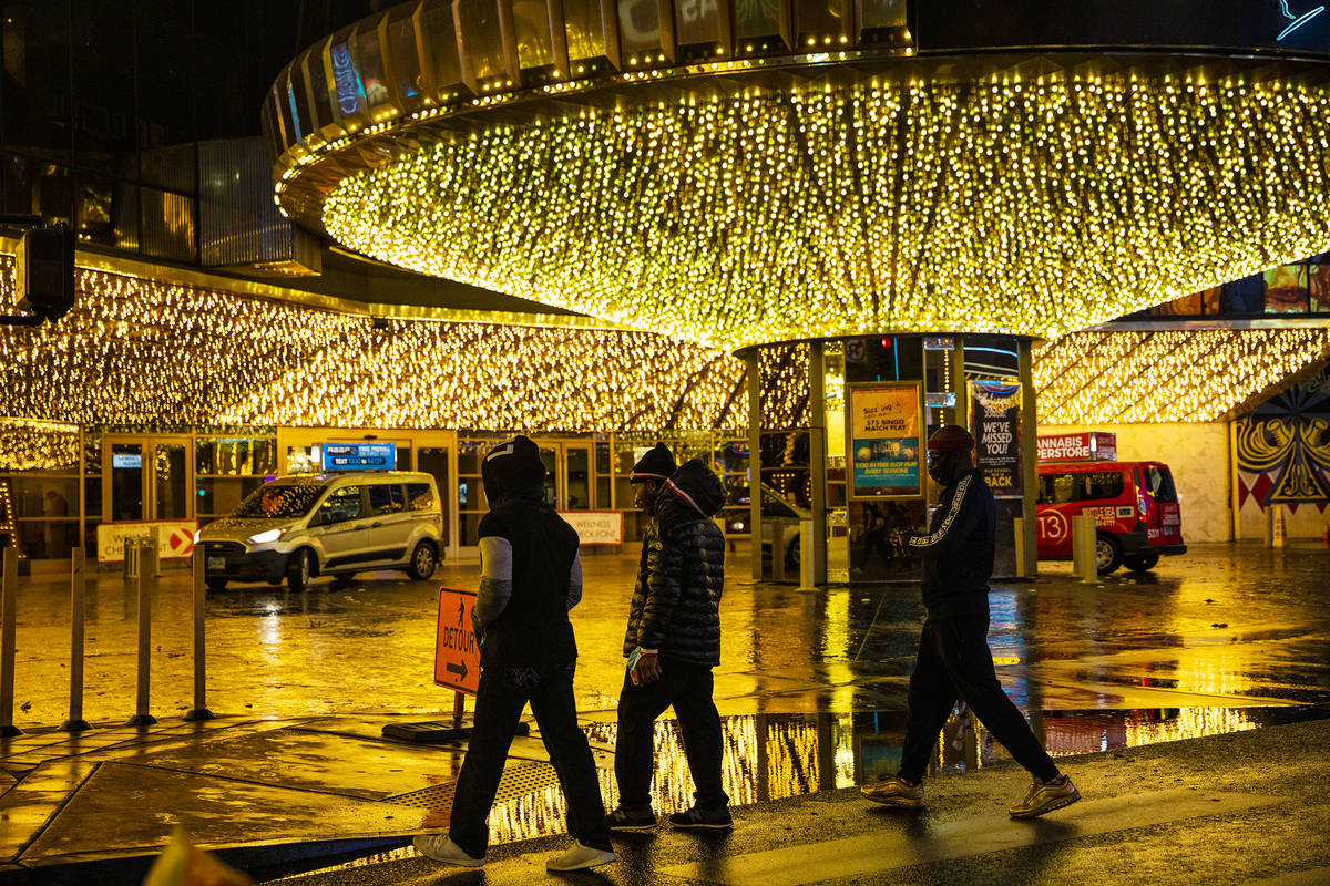 Pedestrians walk past a puddle in front of the Plaza in Downtown Las Vegas, Thursday, Dec. 17, ...