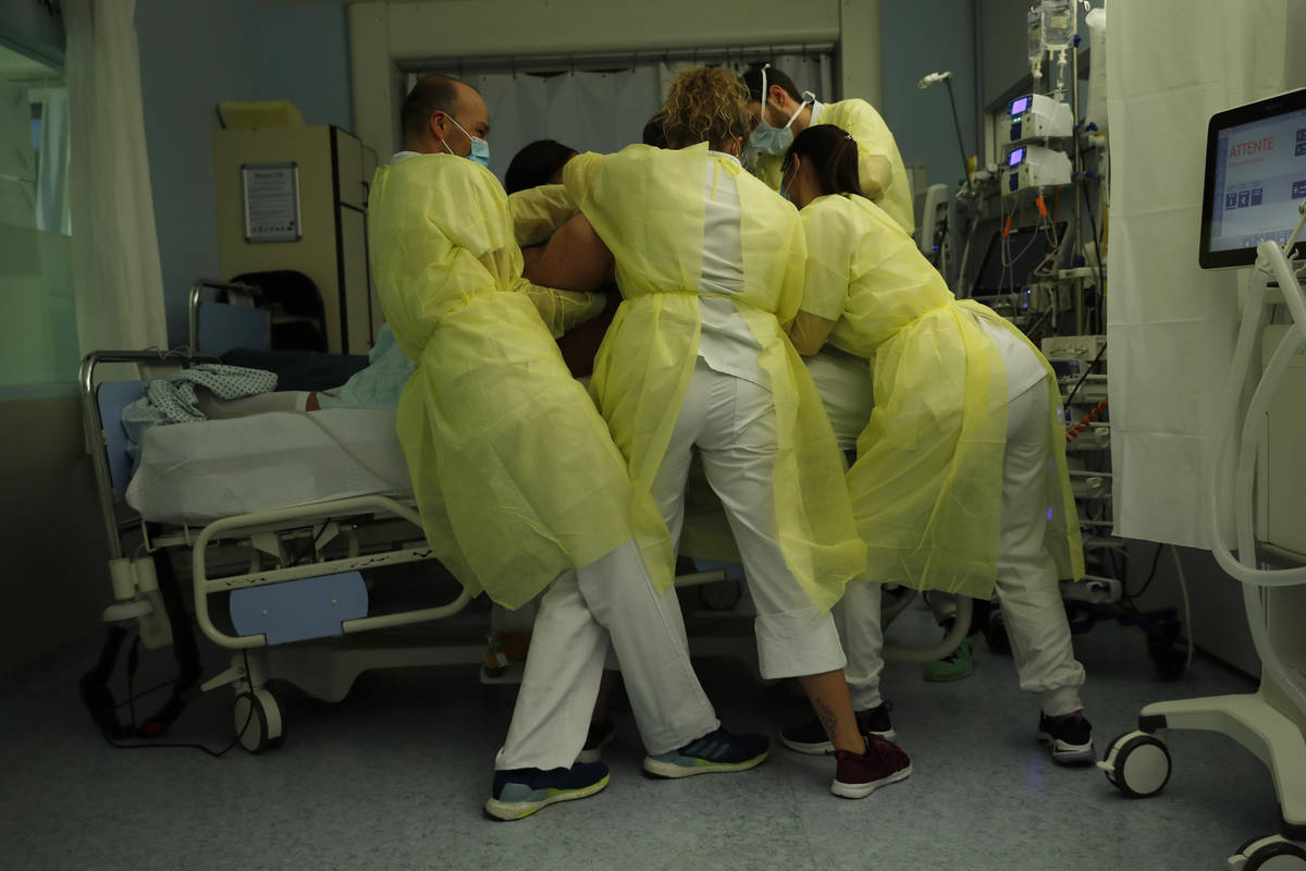 Nurse Anne-Catherine Charlier, right, and co-workers, wearing personal protection equipment, wo ...