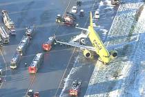 A Spirit Airlines Flight 696 from Las Vegas sits in the snow-covered grass at BWI Marshall Airp ...