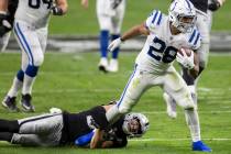 Indianapolis Colts running back Jonathan Taylor (28) fights for extra yardage as Raiders strong ...