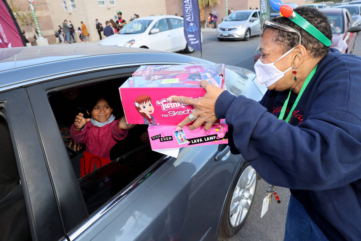 Teacher Candy Collins-Adams hands out gifts to Dafne Arevalo at Martinez Elementary School in ...
