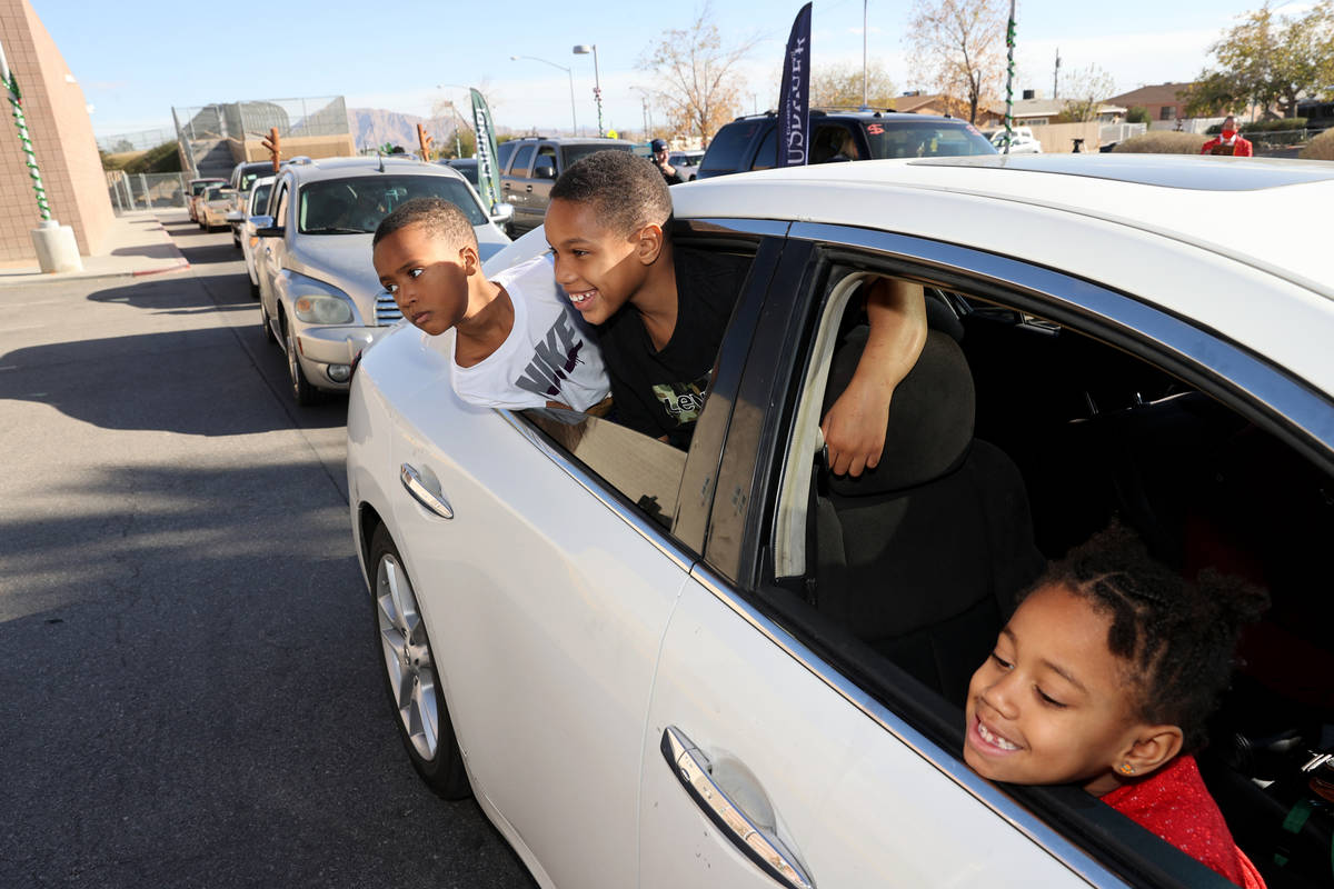 Siblings, from left, Kingston, 5, Kayden, 8, and Brooklyn Bush, 7, wait in line during a drive- ...