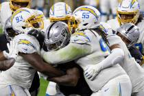 Raiders running back Josh Jacobs (28) is stacked up by Los Angeles Chargers defensive tackle Li ...