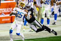 Los Angeles Chargers cornerback Chris Harris (25) gets tackled by Raiders quarterback Marcus Ma ...
