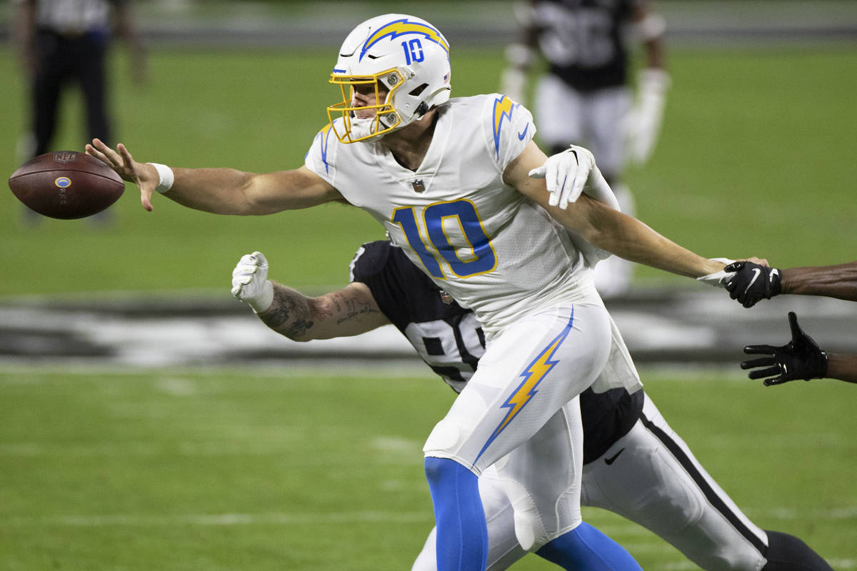 Los Angeles Chargers quarterback Justin Herbert (10) makes a scuffle pass with Raiders defensiv ...