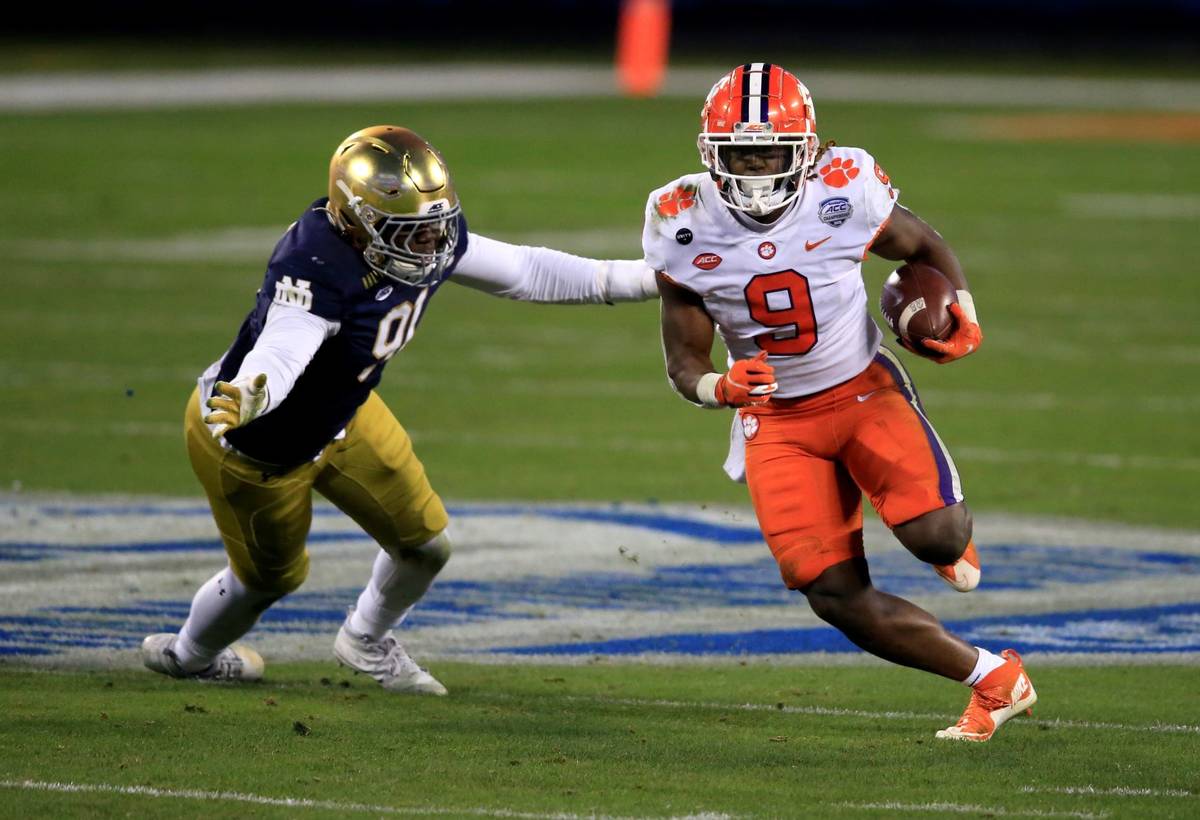Clemson running back Travis Etienne (9) evades a tackle by Notre Dame defensive lineman Adetoku ...