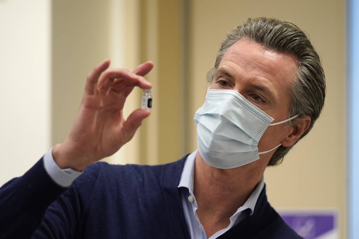 In this Dec. 14, 2020, file photo, California Gov. Gavin Newsom holds up a vial of the Pfizer-B ...