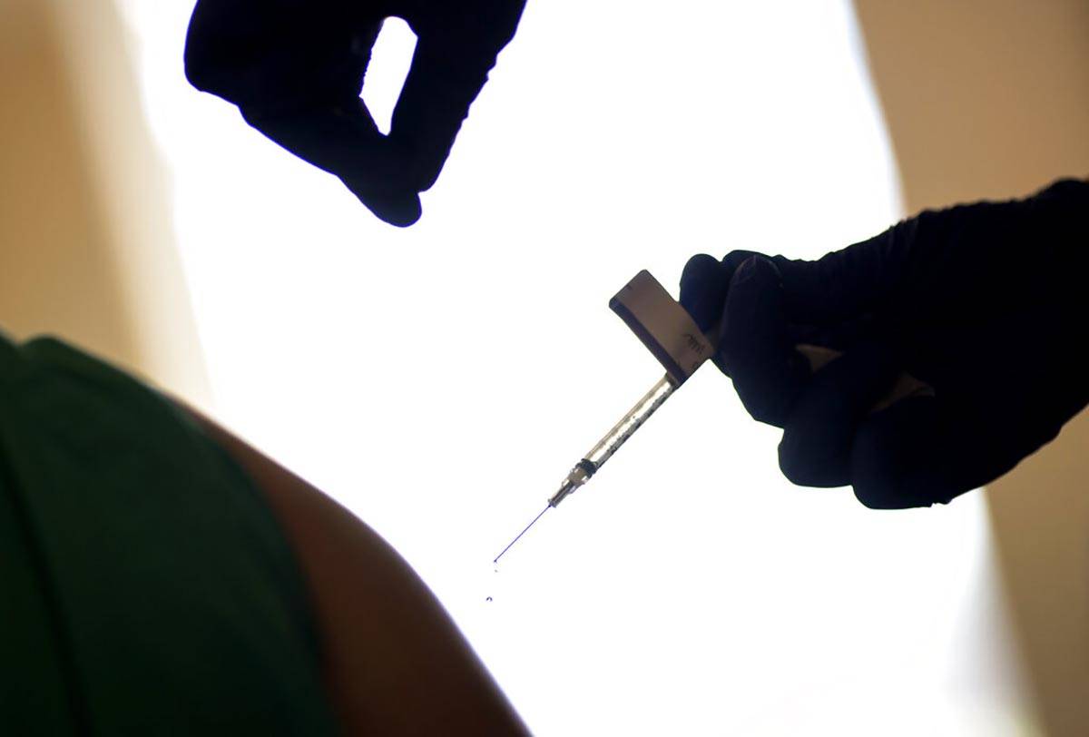 In a Tuesday, Dec. 15, 2020, file photo, a droplet falls from a syringe after a health care wor ...