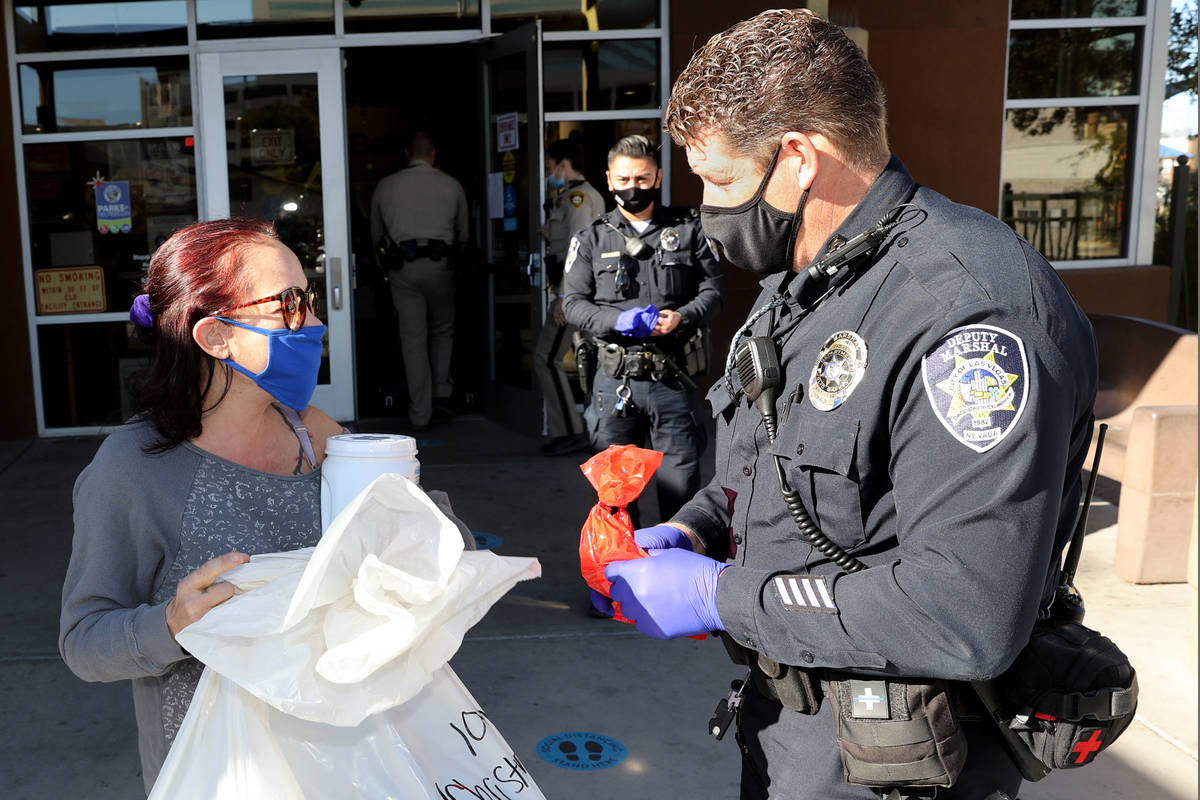 Las Vegas marshal Charles Shepherd gives toys and food to Christina Rivera at Stupak Community ...