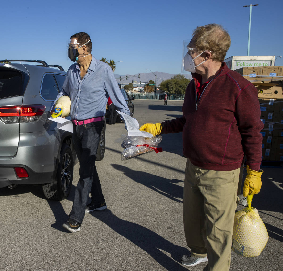 Penn & Teller carry over turkeys and cookies to awaiting vehicles during the re-opening of ...