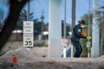 Lettered evidence markers are placed as North Las Vegas Police investigate a homicide along Wes ...