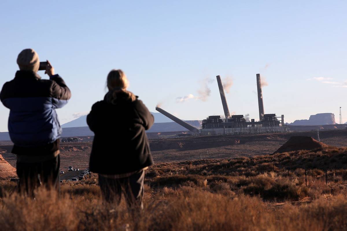 Pat Talbott, right, watches with her son Ted as the first of three structures fall during a con ...