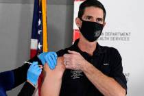 Mesa Fire Department Capt. Jeff Stieber, right, receives the Pfizer-BioNTech vaccine for COVID- ...