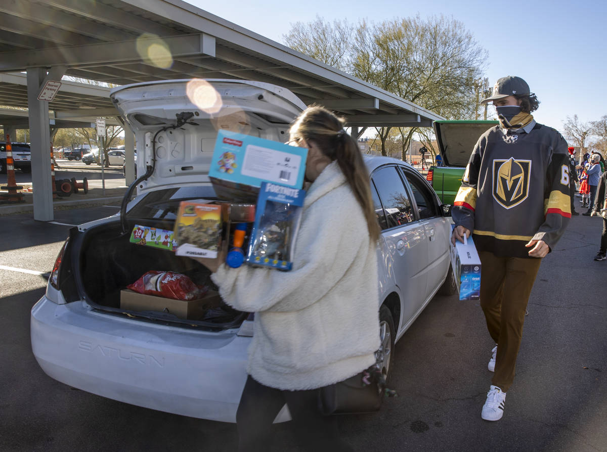 Golden Knights player Mark Stone, right, helps to load up gifts during the first NLVPD Holiday ...