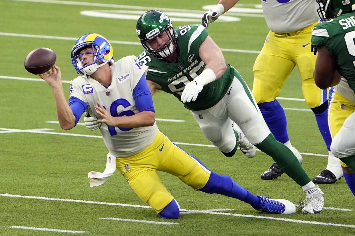Los Angeles Rams quarterback Jared Goff throws the ball away as he is tackled by New York Jets ...