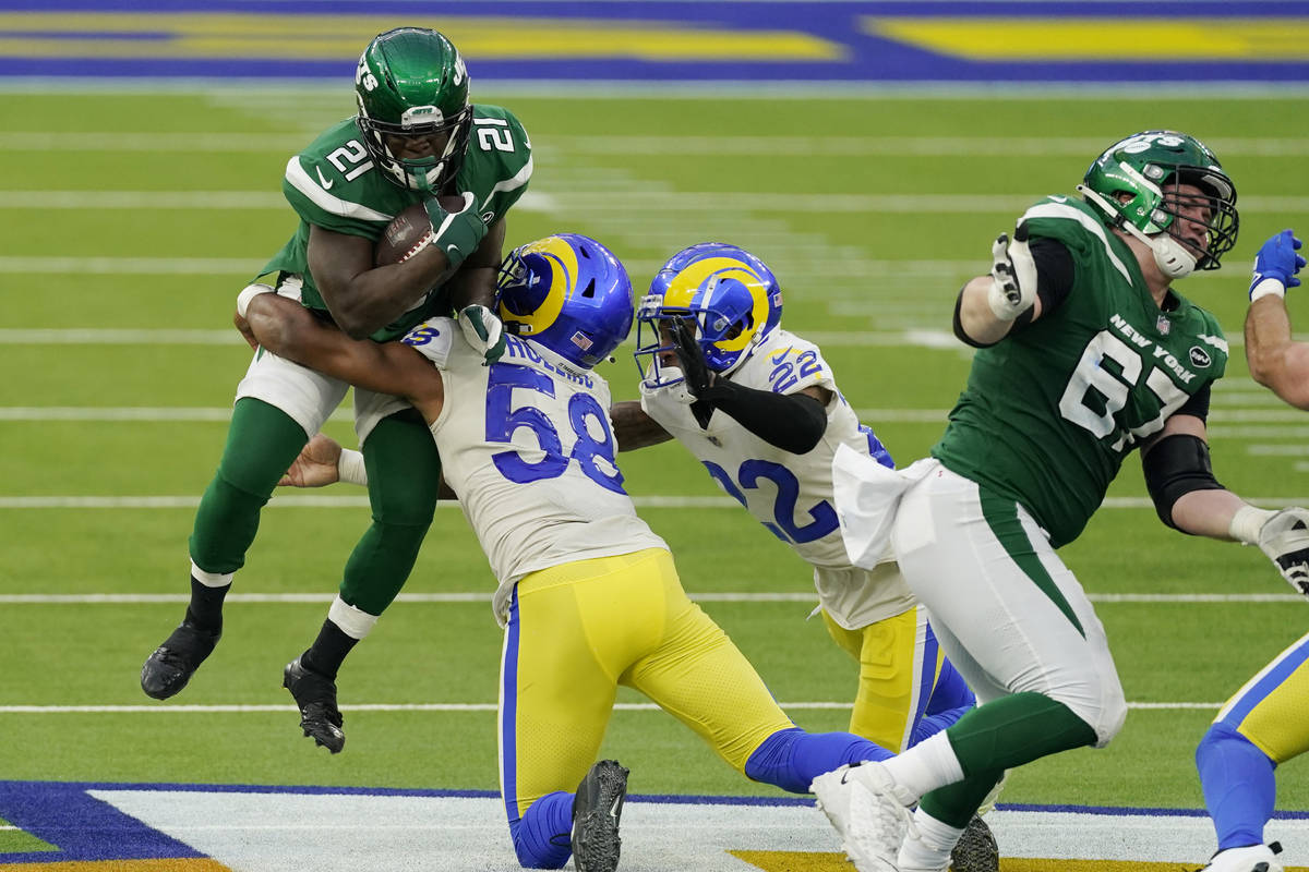 New York Jets running back Frank Gore (21) is tackled by Los Angeles Rams linebacker Justin Hol ...