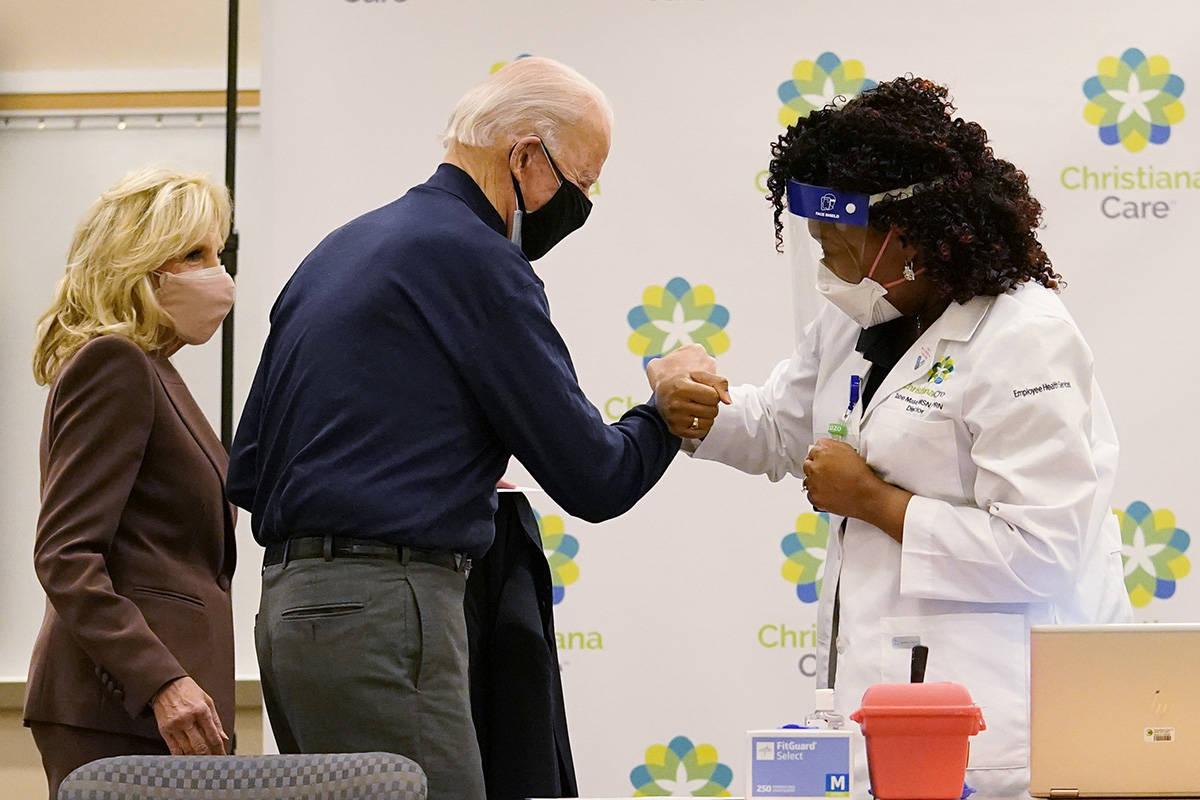 President-elect Joe Biden fist bumps with nurse practitioner Tabe Mase after receiving his firs ...