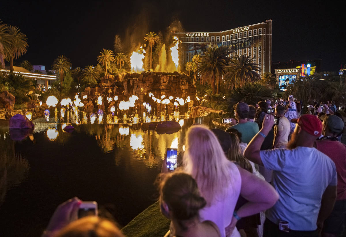 People on the Strip watch the first volcano show since the reopening of the The Mirage earlier ...