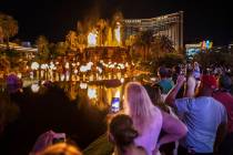 People on the Strip watch the first volcano show since the reopening of the The Mirage earlier ...