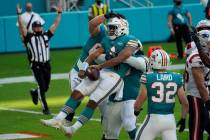 Miami Dolphins quarterback Tua Tagovailoa (1) celebrates his score against the New England Patr ...
