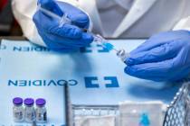 Student pharmacist Wilbur Quimba loads up new syringes with vaccine as University Medical Cente ...