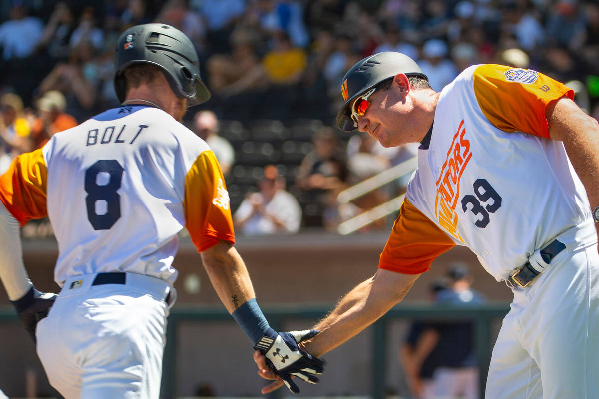 Base runner Skye Bolt (8) is congratulated on a score by Aviators manager Fran Riordan (39) as ...