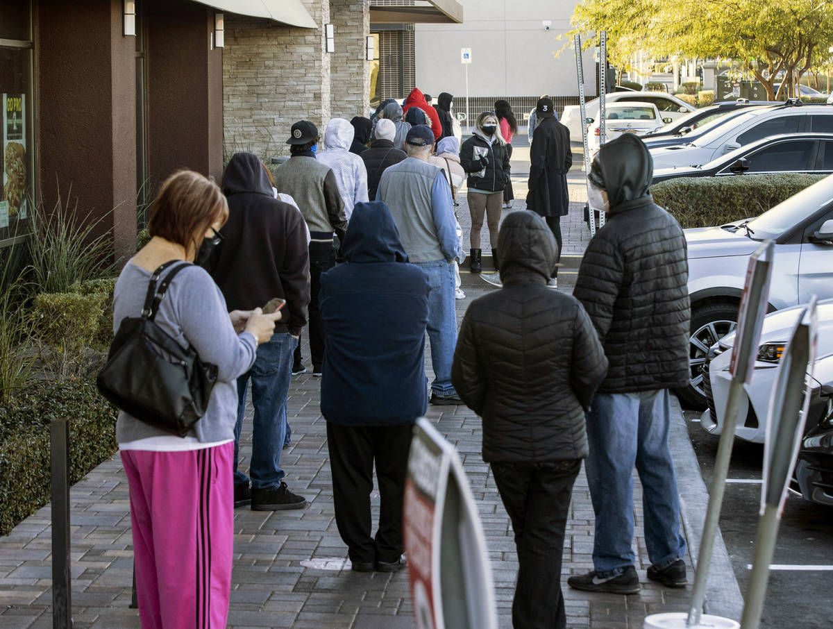 People line up outside of CareNow Urgent Care at 7040 South Durango Drive, on Tuesday, Dec. 22, ...