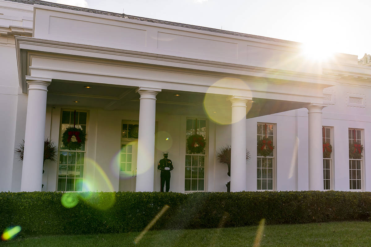 A Marine stands outside the entrance to the West Wing of the White House, signifying the Presid ...