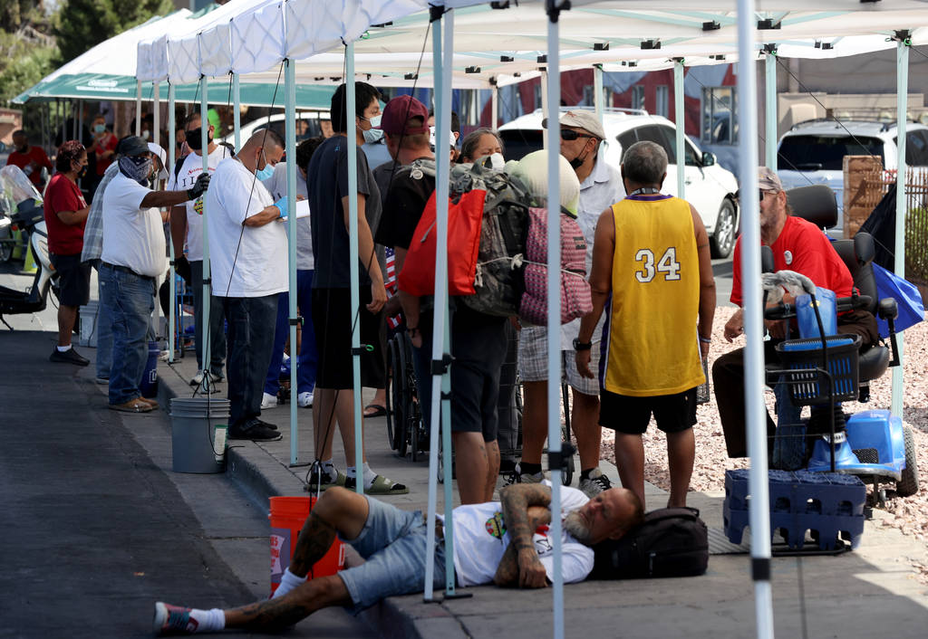 A volunteer registers people lined up for a food distribution at SHARE Village in July. (K.M. C ...