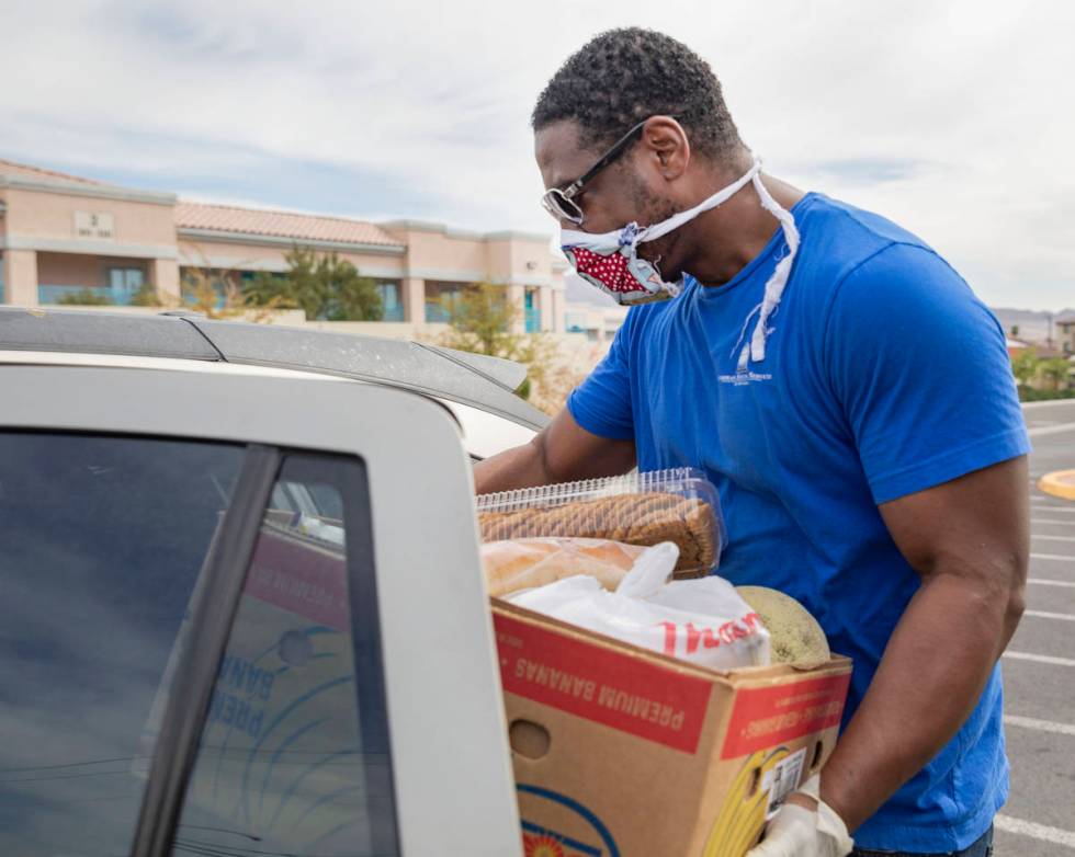 Raymond Watkins, case manager for Lutheran Social Services of Nevada, loads a vehicle with an e ...