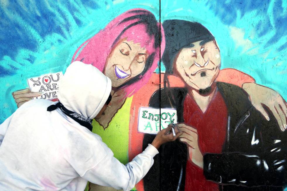 Artist Alexander Sky paints a mural on the boarded up back entrance to ReBar on March 24 in the ...