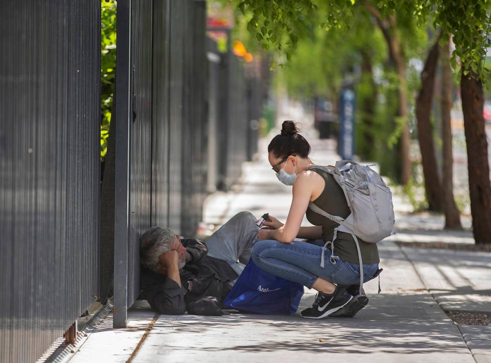 Paramedic Sarita Lundin speaks with a homeless man after handing him a bag of essential supplie ...