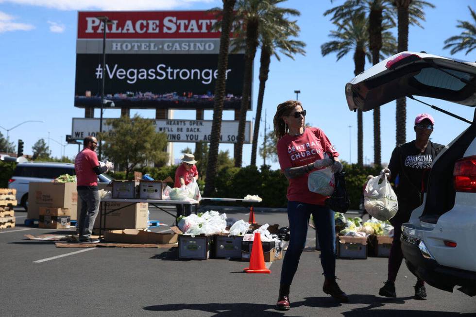 Three Square food bank volunteers Bobbie Bisbee, left, and Monica Smith, give out food at Palac ...