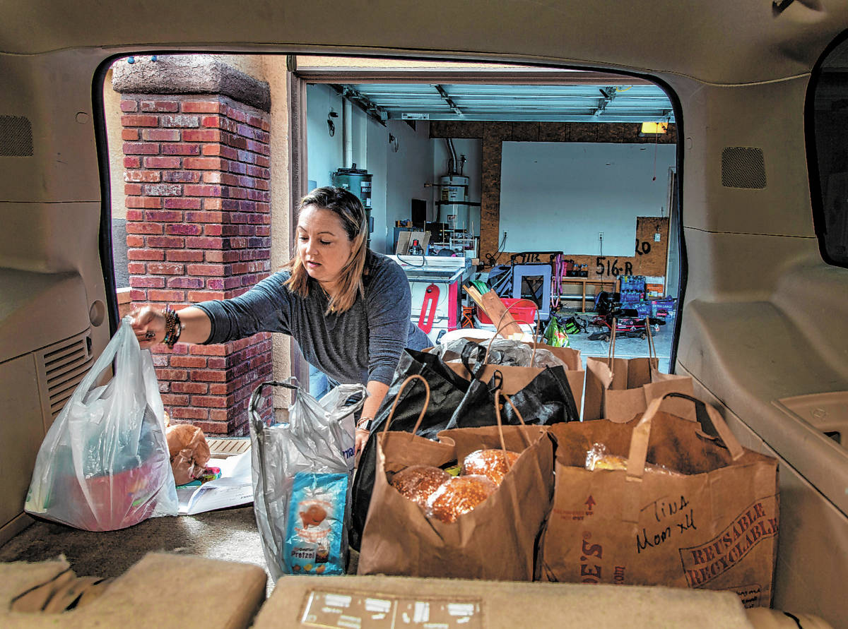 Kat Morris fills her car with food and supplies for another donation drop with the COVID-19 Bar ...