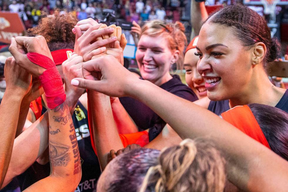 Las Vegas Aces forward Tamera Young (1, left) looks center Liz Cambage (8, right) as teammates ...