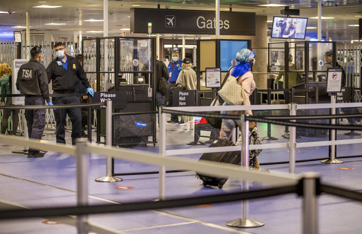Travelers make their way through the TSA checkpoint at Terminal 1 during holiday travel at McCa ...