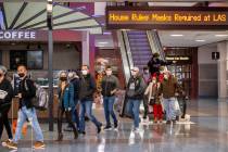 People arrive at baggage in Terminal 1 as holiday travel at McCarran International Airport cont ...