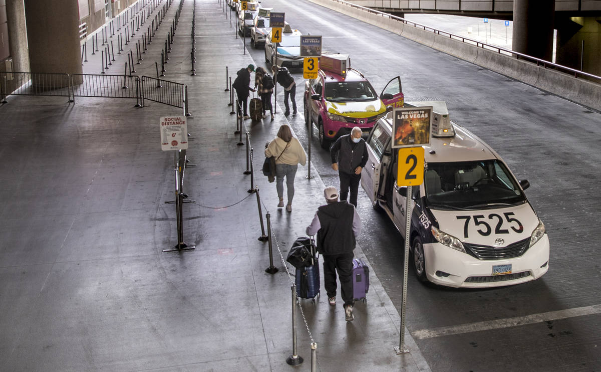 Travelers catch cabs outside Terminal 1 during holiday travel at McCarran International Airport ...