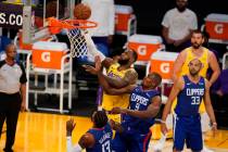 Los Angeles Lakers forward LeBron James, top, drives to the basket over Los Angeles Clippers ce ...
