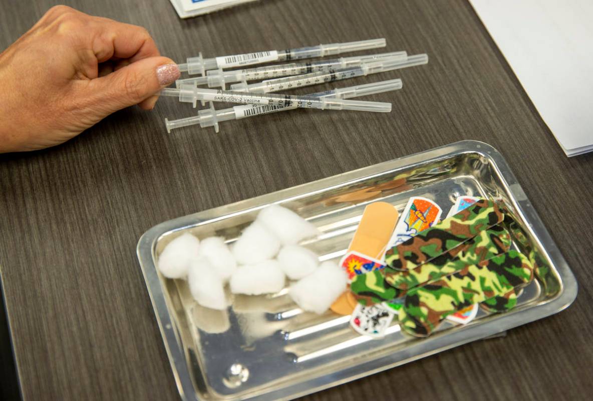 Syringes are loaded as University Medical Center personnel give front-line health care workers ...