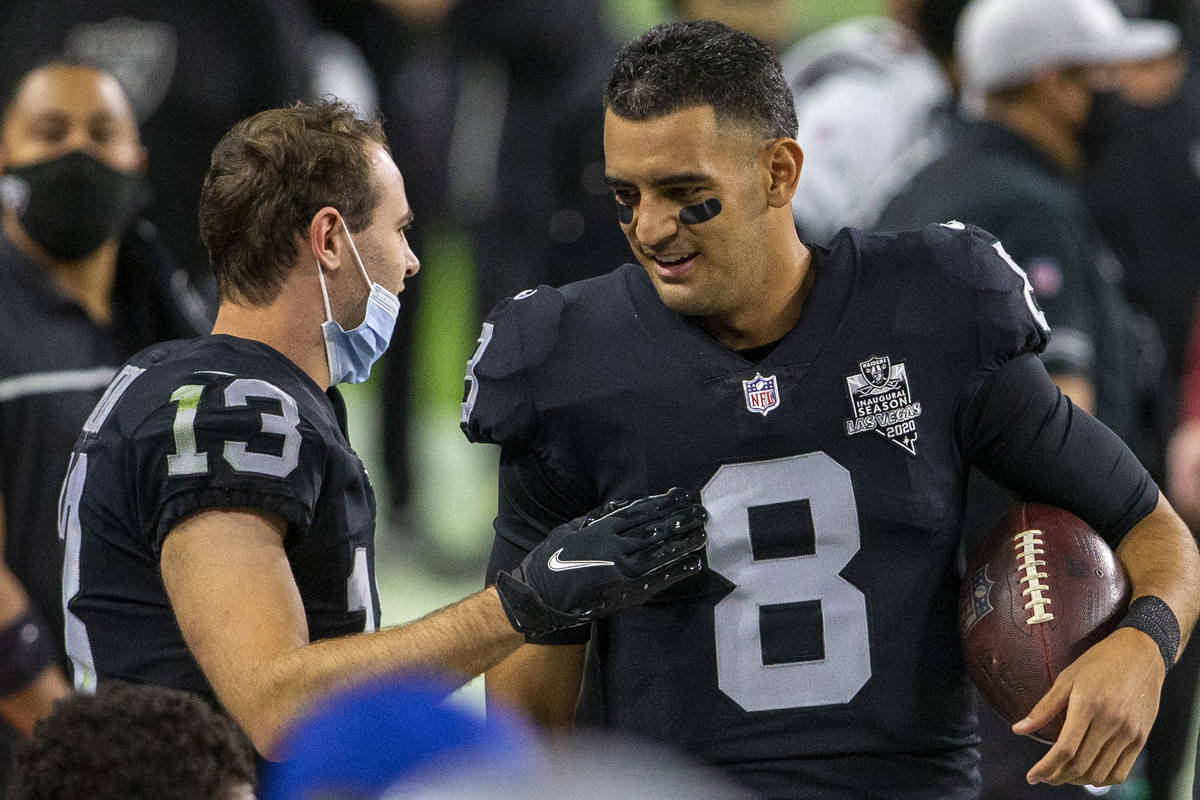 Raiders quarterback Marcus Mariota (8) speaks to Raiders wide receiver Hunter Renfrow (13) befo ...